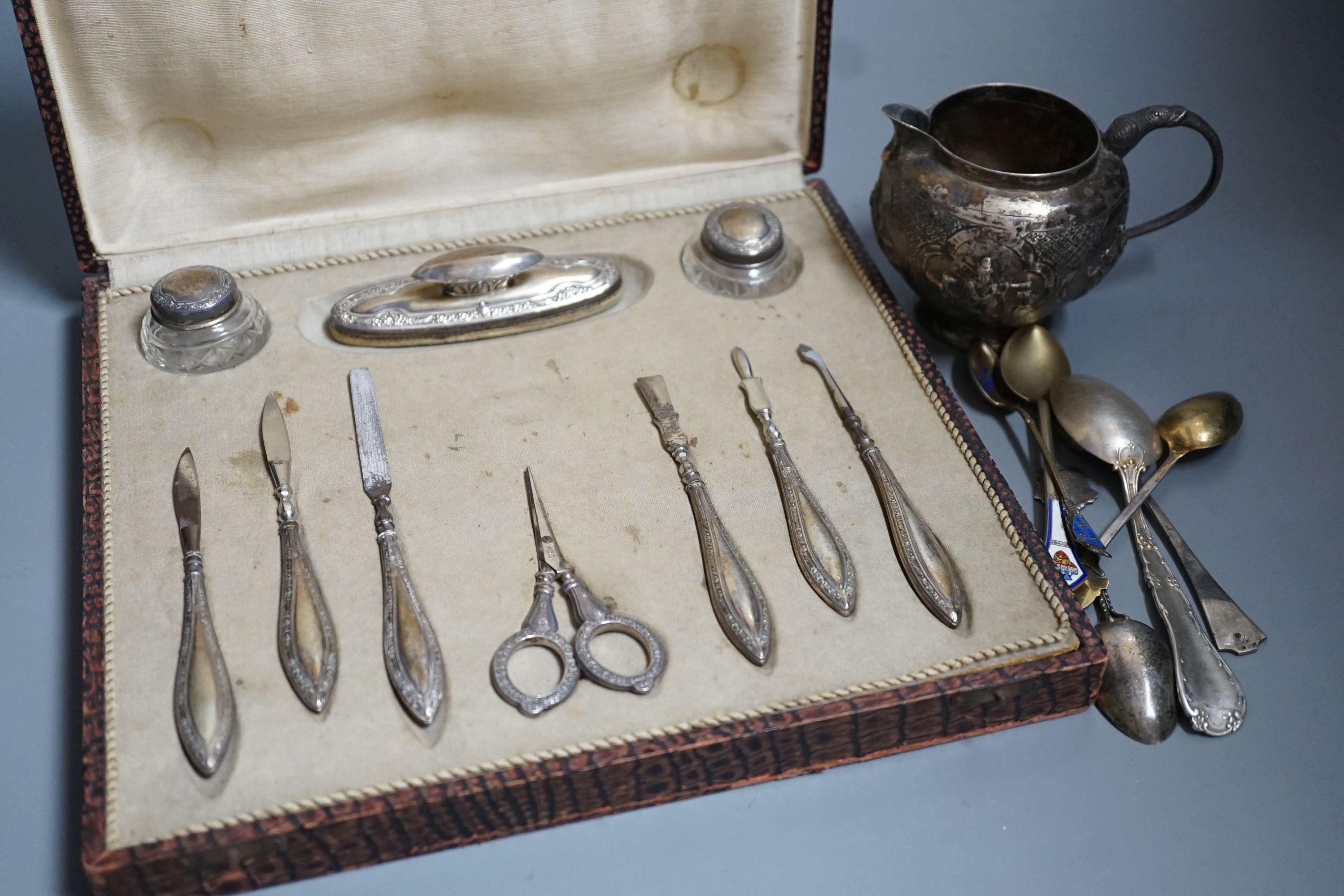 A pair of 1960's silver candlesticks, 19.2cm, weighted, a small silver vase, small silver and tortoiseshell pill box, two small silver armada dishes, two Indian white metal cream jugs, four 'coin' dishes, a quantity of a